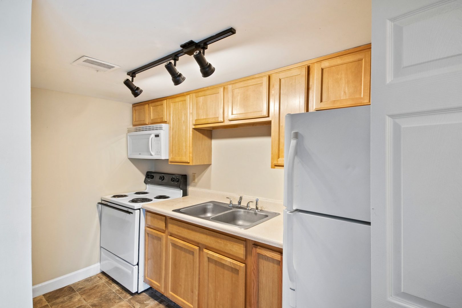 kitchen with white cabinets and stainless steel appliances at The Courts of Monon